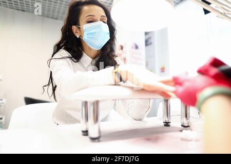 Porträt einer Kundin, die bei einem Termin im schützenden Gesicht sitzt Maske Stockfoto