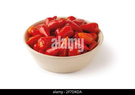 Eingelegte rote Paprika in einer Schüssel isoliert auf weißem Hintergrund. Marinierte kleine Paprika aus der Nähe. Fermentiertes Bio-Gemüse. Stockfoto