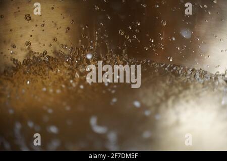 Tibetische Klangschale voller Wasser, Nahaufnahme von Wassertropfen, Klangheilungsinstrument Stockfoto