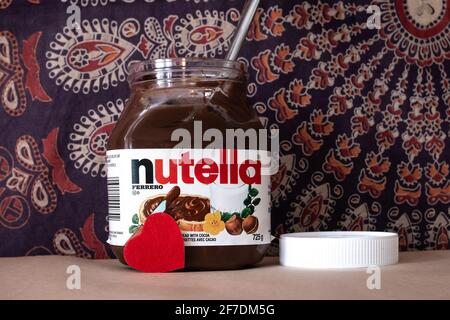 Toronto, Ontario, Kanada - 4 2021. Februar: Ein Glas Nutella, eine Haselnuss, vor einem Mandala-Wandteppich. Der 5 2021. Februar ist der Welt-Nutella-Tag. Stockfoto