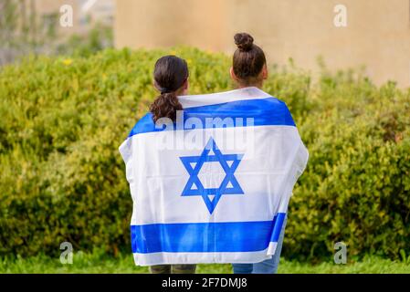 Zwei patriotische jüdische Teenager Mädchen stehen und genießen mit der Flagge Israels auf Natur Hintergrund.Memorial Day-Yom Hazikaron, Vaterländischen Feiertag Unabhängigkeitstag Israel - Yom Ha'atzmaut Konzept. Stockfoto