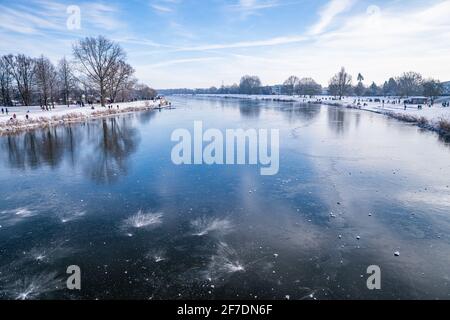 Schöner gefrorener Fluss namens werdersee an sonnigen, warmweißen Wintertagen mit schneebedecktem Deich in bremen, Blick von der Brücke Stockfoto