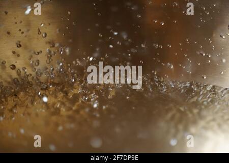 Tibetische Klangschale voller Wasser, Nahaufnahme von Wassertropfen, Klangheilungsinstrument Stockfoto