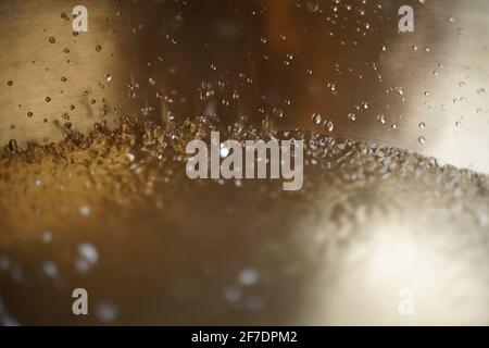 Tibetische Klangschale voller Wasser, Nahaufnahme von Wassertropfen, Klangheilungsinstrument Stockfoto