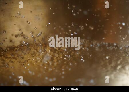 Tibetische Klangschale voller Wasser, Nahaufnahme von Wassertropfen, Klangheilungsinstrument Stockfoto