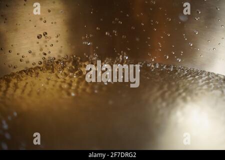 Tibetische Klangschale voller Wasser, Nahaufnahme von Wassertropfen, Klangheilungsinstrument Stockfoto