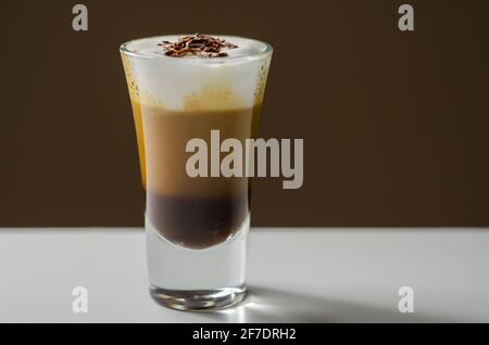 Kaffeegetränk, mit einer nussigen Note mit flauschigem Milchschaum, verziert mit Schokoladenspan, süßem Getränk Stockfoto