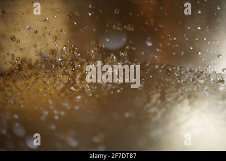 Tibetische Klangschale voller Wasser, Nahaufnahme von Wassertropfen, Klangheilungsinstrument Stockfoto