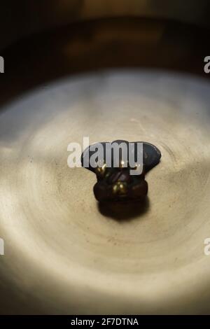 Ganesha-Gottheit sitzt in bronzefarbener tibetischer Klangschale. Stockfoto