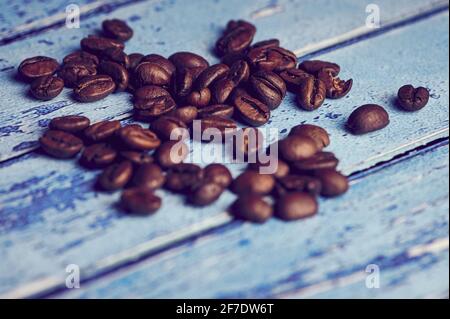 Nahaufnahme der Kaffeebohnen vor blauem Hintergrund Stockfoto