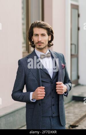 Stilvoller, hübscher Mann mit Bart, in Anzugjacke und Hemd, im Freien auf der Straße der Stadt. Details des klassisch eleganten formellen Herren-Outfits. Stockfoto