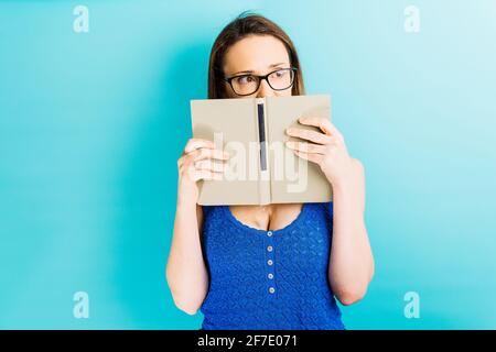 Schöne junge Frau Porträt über ihr Gesicht Blick auf die Seite auf der guten Seite. Lesekonzept Schüchternheit Konzept Stockfoto