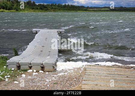 Ein schwimmendes Dock auf einem weiß bedeckten See mit Wellen Stockfoto