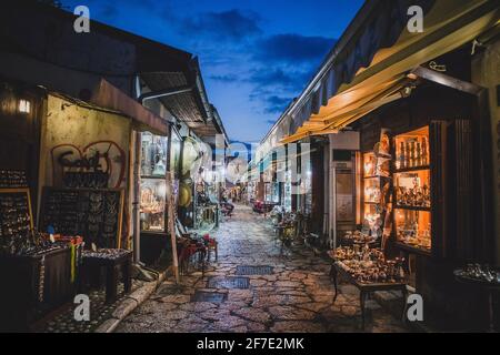 Eine Straße mit kleinen Geschäften, die am späten Abend in Bascarsija, Sarajevo, Souvenirs mit Handicap verkaufen. Stockfoto