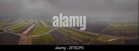 Nasse landwirtschaftliche Felder aus hoher Perspektive. Regenzeit im Herbst in Mitteleuropa, mit Blick auf überflutete Felder und Wiesen Stockfoto