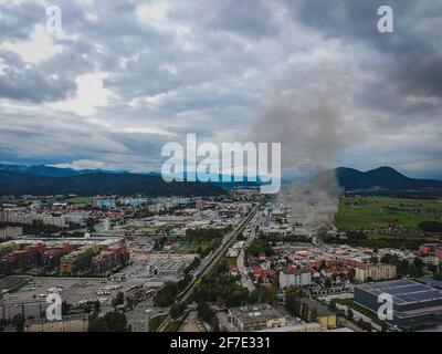 Luftaufnahme eines Brandes im Industriegebiet Stegne in Ljubljana, Slowenien. Dunkle Rauchwolke steigt vom Zündort aus sichtbar auf. Gefahr Stockfoto