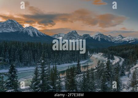 Berühmte Morant's Kurve in der Nähe von Lake Louise in Alberta, Kanada an einem schönen sonnigen Winterabend. Spuren neben einem Fluss sind zu sehen. Stockfoto