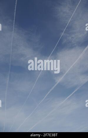 Wolkiger Himmel mit Contrails Stockfoto