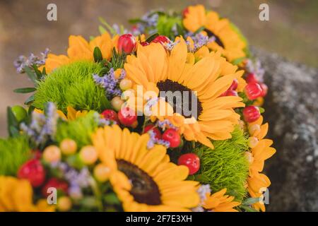 Vintage Hochzeitsstrauß aus trockenen Blumen, Gras, Kirschen und Sonnenblumen. Vintage Hochzeitsstrauß im Detail. Stockfoto