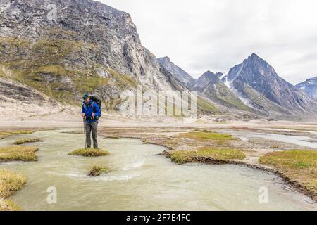 Backpacker stehen auf einer grasbewachsenen Insel in der Mitte eines Flusskanal Stockfoto