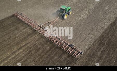 Der Traktor kultiviert die Bodenansicht von der Drohne aus Stockfoto