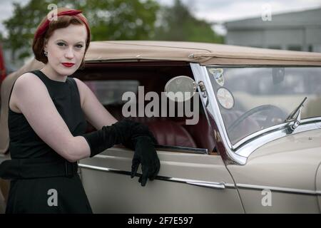 GROSSBRITANNIEN / England /Drive Style /Junge Frau in Vintage-Kleidung posiert mit 1936 Bentley Oldtimer . Stockfoto