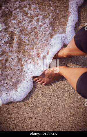 Person, die im Wasser an einem Strand in Hawai'i steht Stockfoto