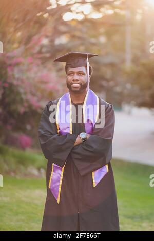 Der Mann freute sich, das College zu besuchen und trug ein Abschlusskleid/Mütze Stockfoto