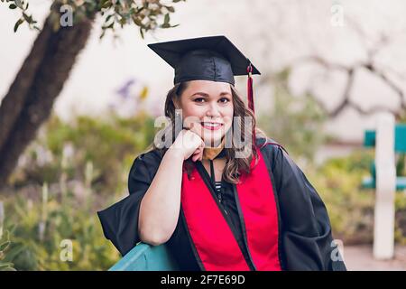 Junge Frau mit Abschlusskleid/-Mütze. Stockfoto