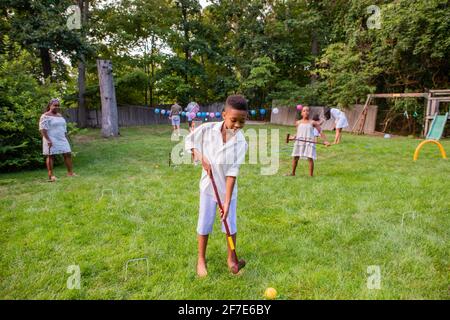 Kinder spielen Cricket auf der Rasenparty Stockfoto