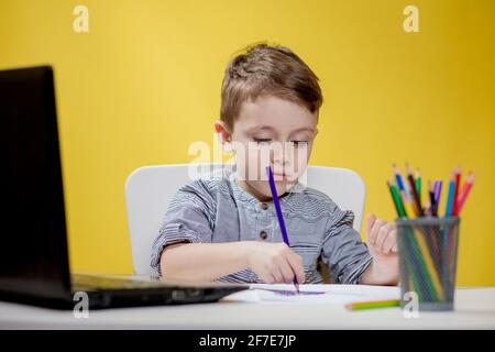 Fernunterricht Online-Bildung. Ein Junge sitzt zu Hause und macht Schulaufgaben, Quarantäne zu Hause Fernunterricht. Stockfoto