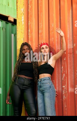 Zwei multiethnische junge Frauen in Stadtkleidung posieren bei Sonnenuntergang Stockfoto