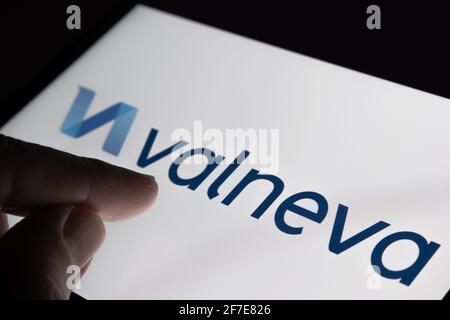 Valneva COVID-19 Impfstoffkonzept. Finger zeigt auf das Firmenlogo von Valneva auf dem unscharfen Hintergrundbildschirm. Stafford, Großbritannien, 6. April 2021. Stockfoto
