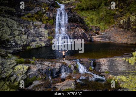 Drohnenansicht eines kaukasischen Mannes auf Fisgas de Ermelo Wasserfall Stockfoto