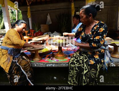 Balinesin bereitet eine handgemachte Opfergabe namens Jajan Suci oder Palegembai in einem Hindu-Tempel in Bali, Indonesien, vor. Stockfoto