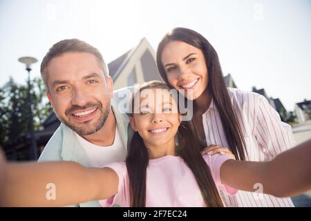 Selbstporträt der attraktiven fröhlichen Familie Mama Papa umarmt Jugend Tochter Viel Spaß in der Cottage Town im Freien Stockfoto