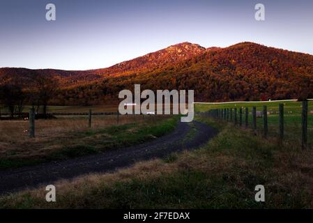 An einem Herbstmorgen erhellt das Sonnenlicht den Old Rag Mountain und die Herbstfarben des Shenandoah National Park von einer nahe gelegenen Farm in Virginia. Stockfoto