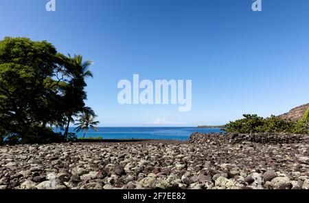 Vorderansicht eines Felsstrandes in Hawaii mit Pazifik Ozean und Himmel im Hintergrund Stockfoto