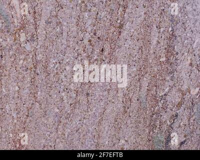 Textur aus rotem Stein mit einem Riss. Roter Marmor an der Wand. Marmorboden. Stockfoto