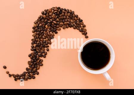 Beige flach Lay Hintergrund mit weißer Keramik Tasse Kaffee, geröstete Kaffeebohnen Dampf Form von heißem Kaffee. Idee und Zusammensetzung mit Kaffeebohnen s Stockfoto
