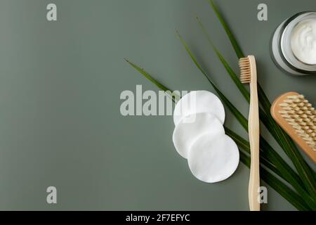 Bad Accessoires flay Lay, pastellgrün Hintergrund. Gesundheitskonzept, Palmblatt, Zahnbürste aus Holz, Fußbürste, Wattepads, Cremefarbene Flasche. Eco, zer Stockfoto