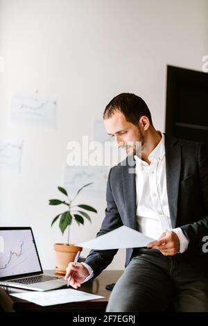 Konzentrierter Finanzmanager, der Daten im Büro analysiert Stockfoto