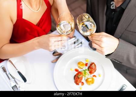 Paar für ein romantisches Abendessen oder Mittagessen in einem Gourmet-Restaurant Trinken Sie Weißwein und gutes Essen Stockfoto
