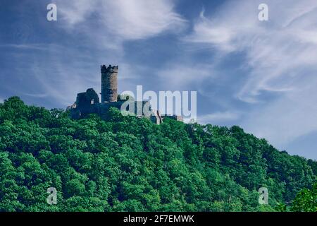 Mittelalterliche Burg auf einem Hügel an nebligen Tag. Altes Schloss Muhlburg inmitten grüner Bäume auf einem Hügel gegen wolkigen blauen Himmel an trüben Tagen in Thüringen, Deutschland Stockfoto
