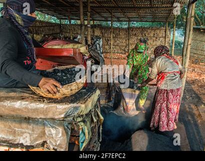 Eine weibliche Arbeitskraft arbeitet auf einem Ziegelfeld in Khulna, Bangladesch, mit Kohle. Stockfoto