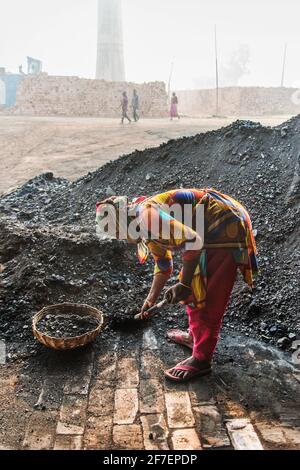 Eine weibliche Arbeitskraft arbeitet auf einem Ziegelfeld in Khulna, Bangladesch, mit Kohle. Stockfoto