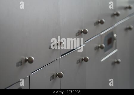 Nahaufnahme von vielen Schließfächern oder Metall- oder Holzschrankboxen. Schließfächer mit Nummern, rfid-Codes und runden Knöpfen. Stockfoto