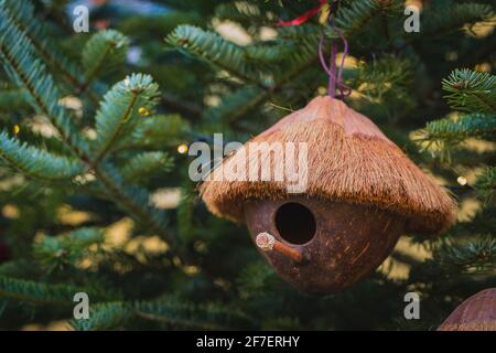 Genious Idee - ein Vogelhaus aus Kokosnuss ist Hängen an einem weihnachtsbaum während des christkindl-Marktes in Österreich Stockfoto