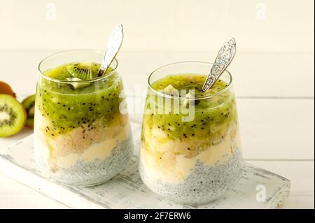 Chia-Samenpudding mit Kiwi, Banane und Mango. Health Detox Frühstück in Gläsern auf weißem Hintergrund. Stockfoto