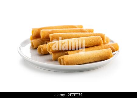 Süße Waffelröhrchen Rollen auf Platte isoliert auf weißem Hintergrund. Stockfoto